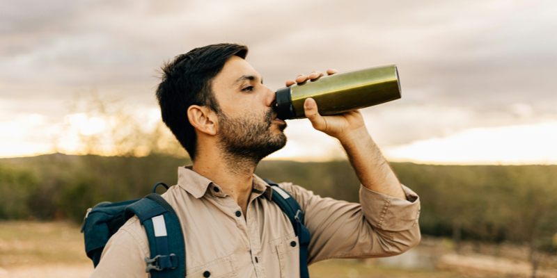 Hiker drinking from a reusable water bottle.