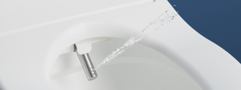 close up of Brondell stainless steel nozzle spraying water from the bidet